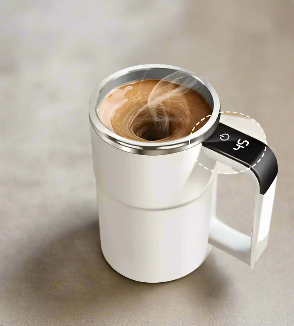 White electric coffee maker with a digital temperature display on a white surface with coffee beans.